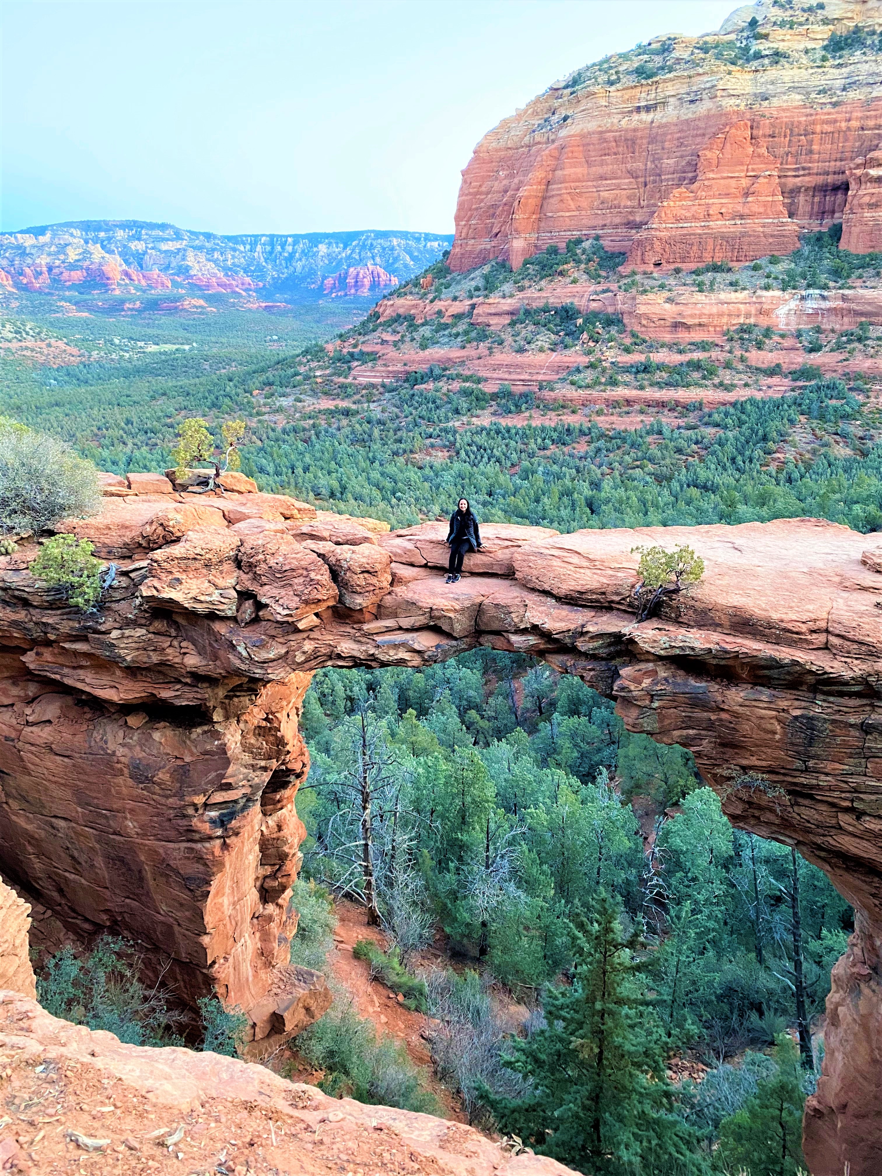 A woman sitting on Devil's Bridge in Sedona Arizona