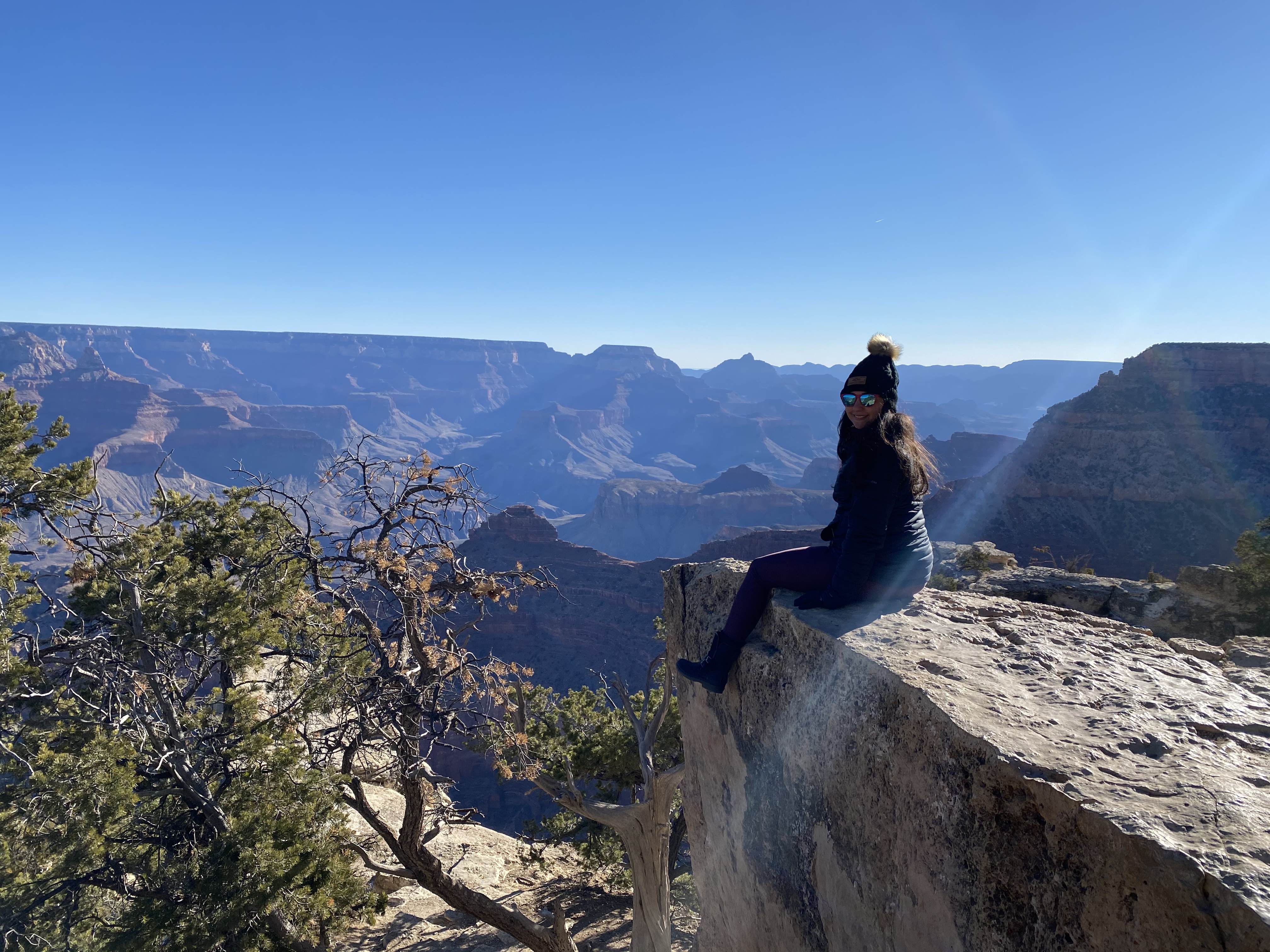 Young Woman Sitting on the Edge of a Rock at the Grand Canyon