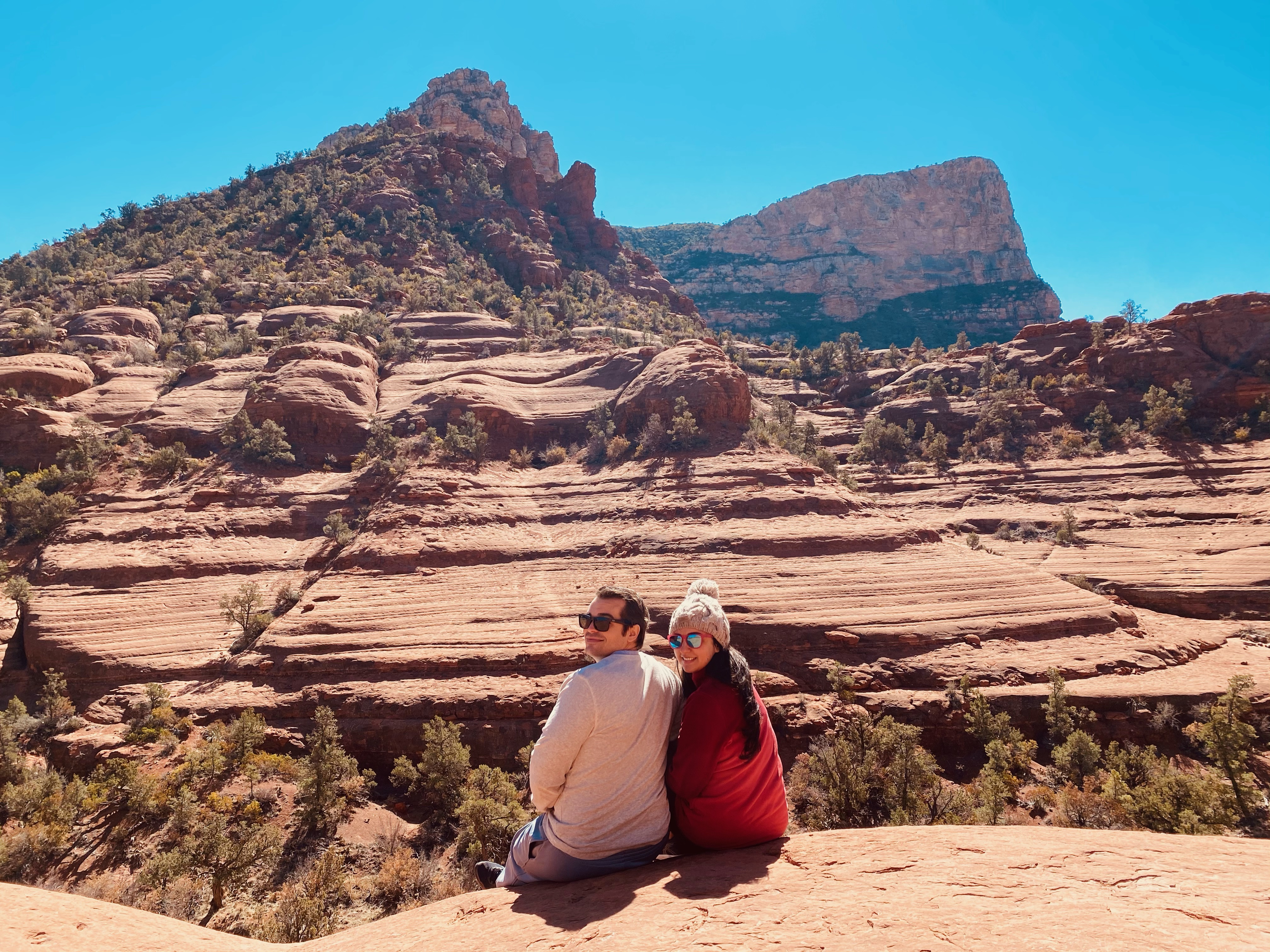 A couple sitting among the Red Rocks in Sedona Arizona