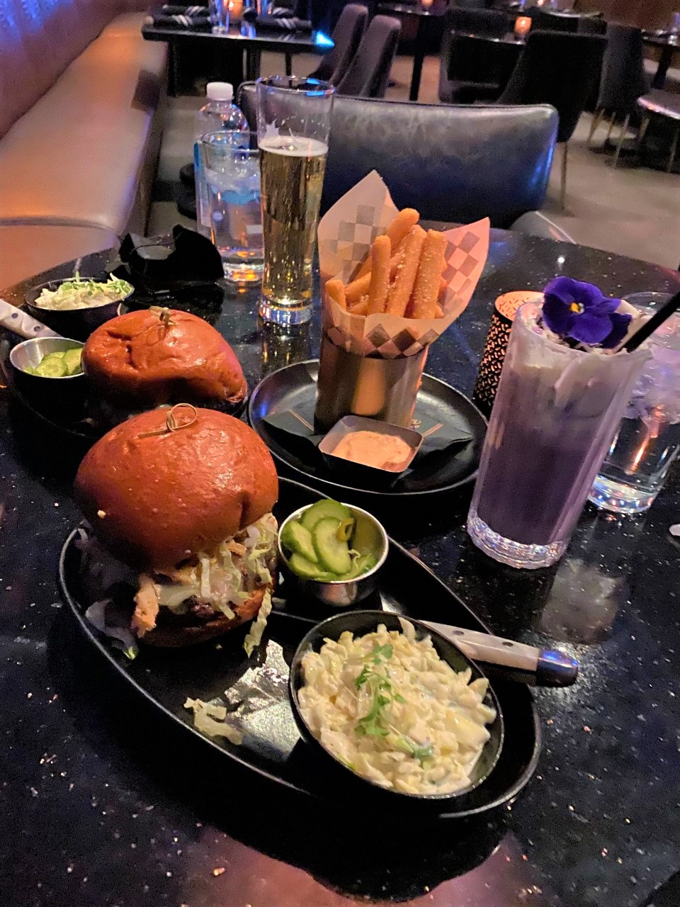 burgers, fries, and drinks on a table at a restaurant