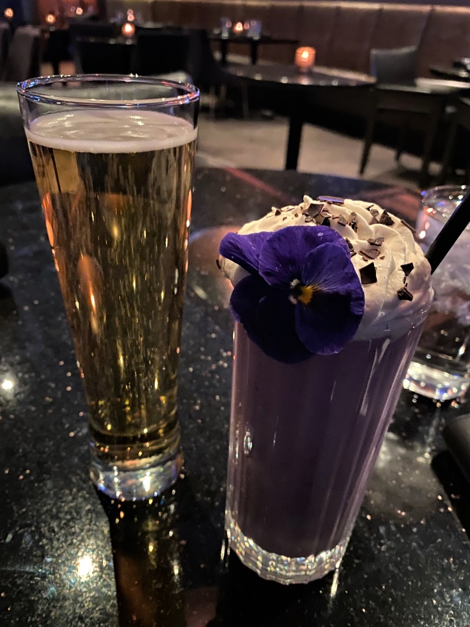 Lavender milkshake and a beer on a table at a restaurant 