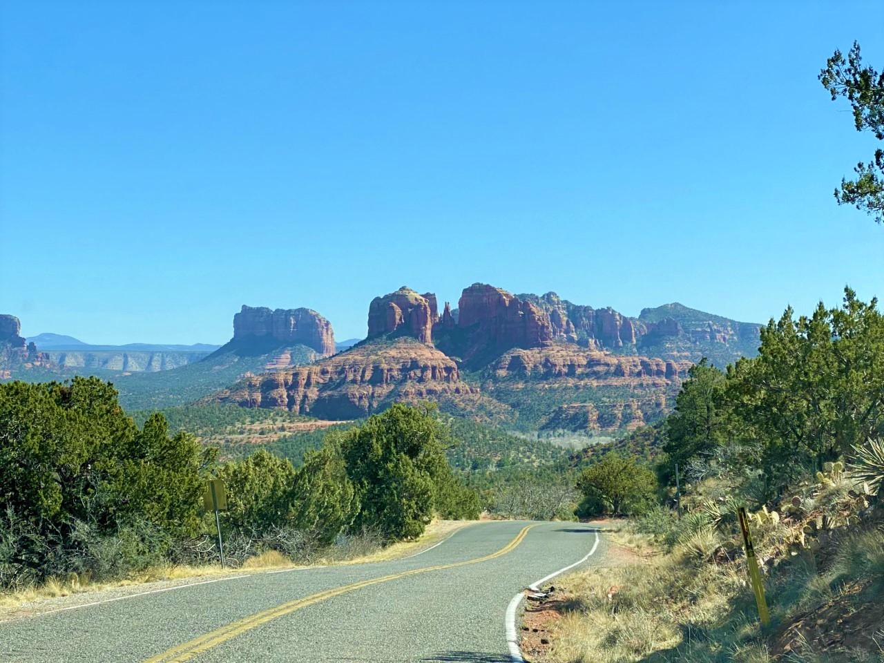 A road in Sedona, Arizona with the red rocks in the background 