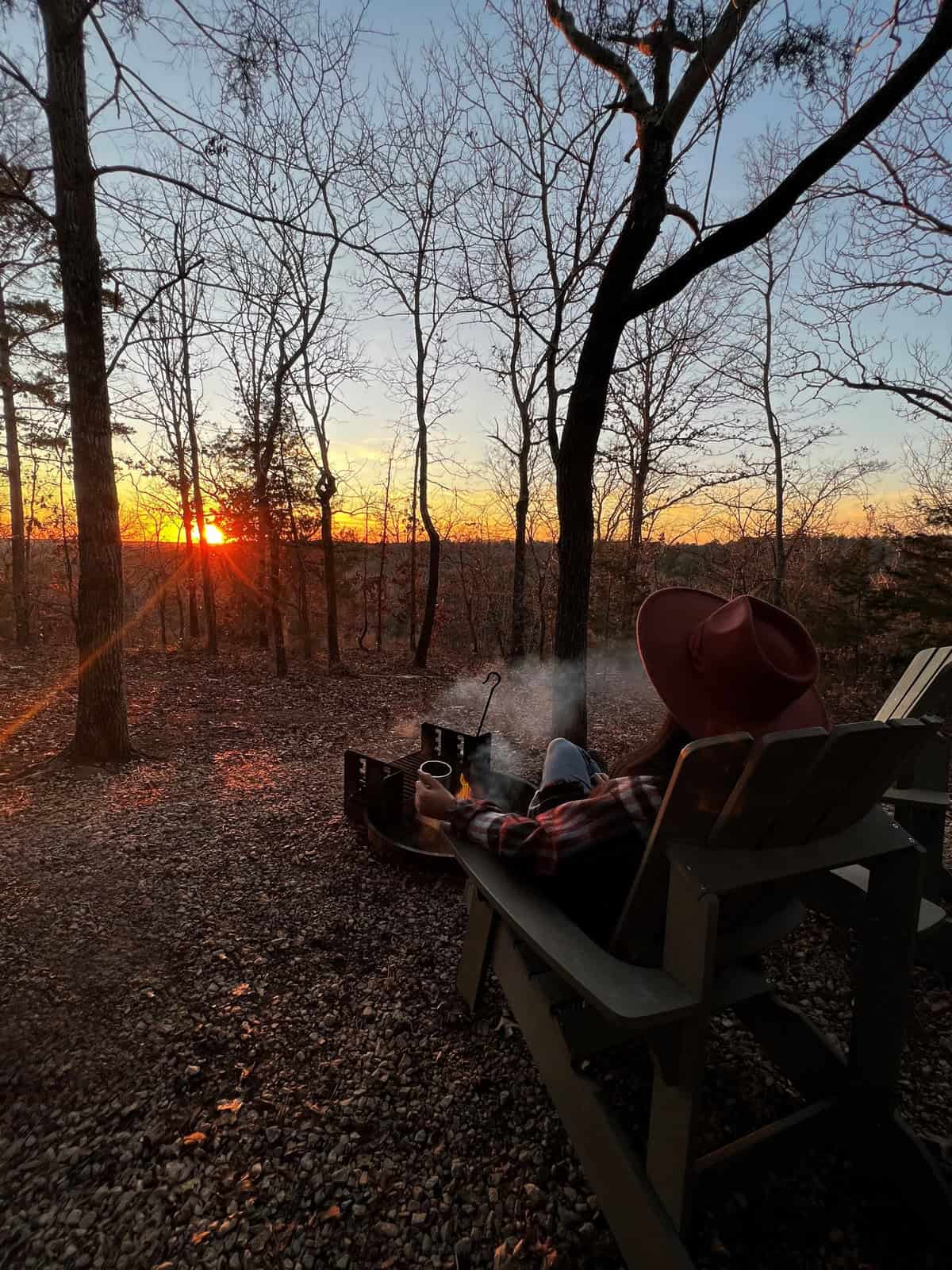 a women sitting in front of a firepit