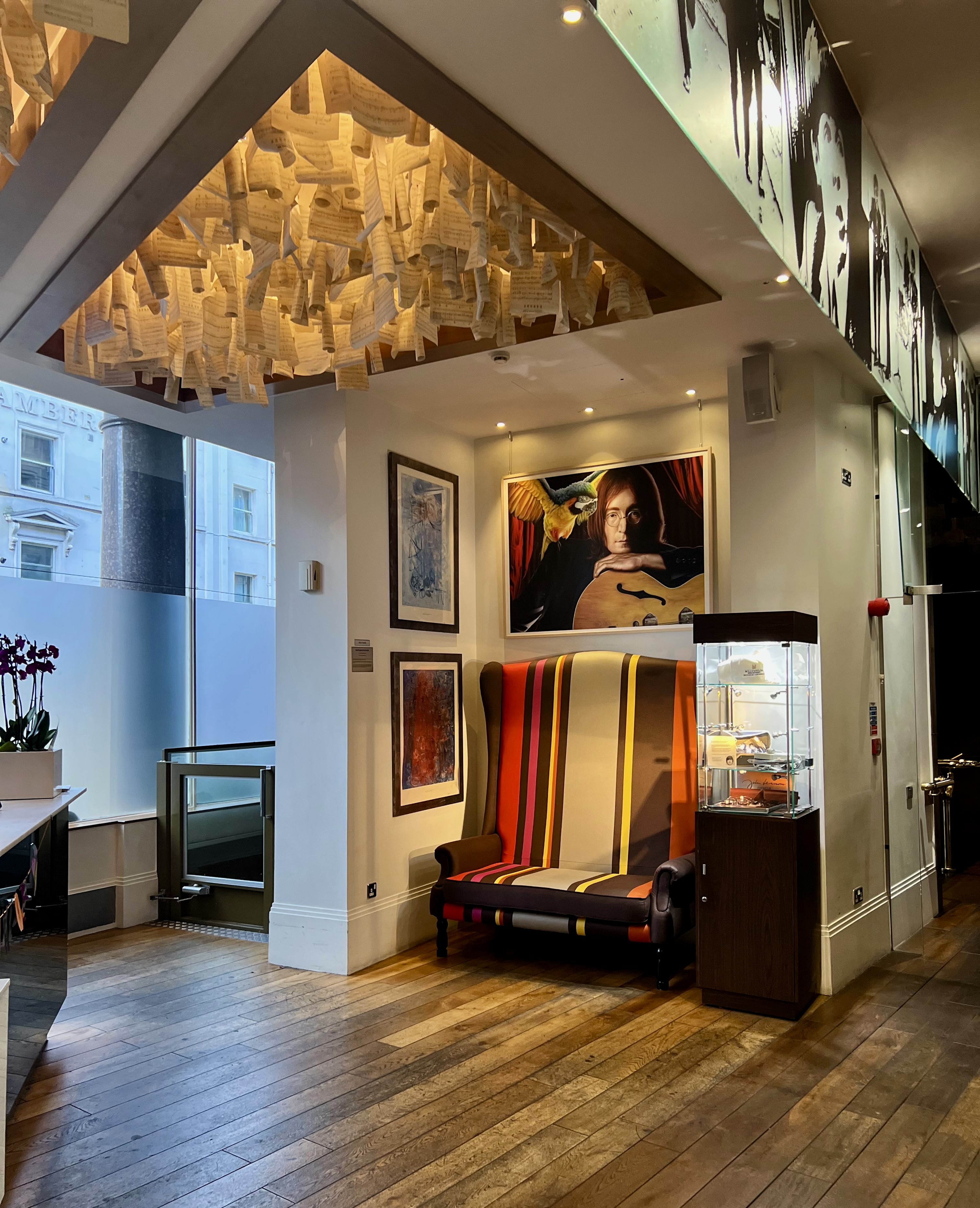 The lobby of a Beatles-themed hotel with portraits of the band and music lyrics hanging from the ceiling