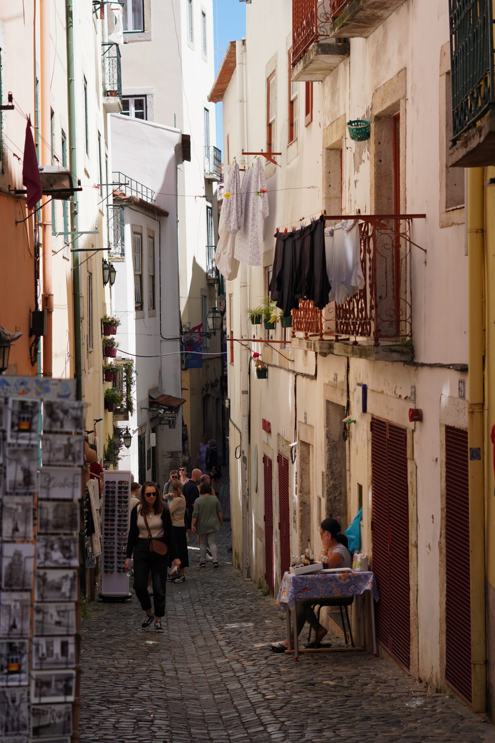 people walking in an alleyway of an old and charming neighborhood in Lisbon