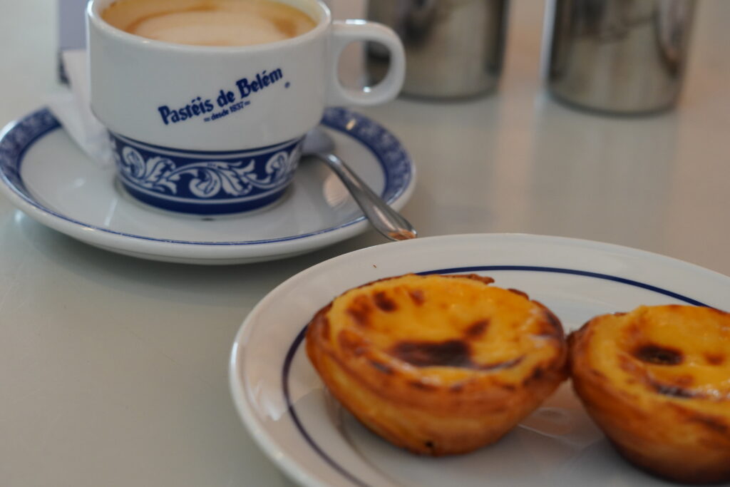 a cup of coffee and a Portuguese pastry