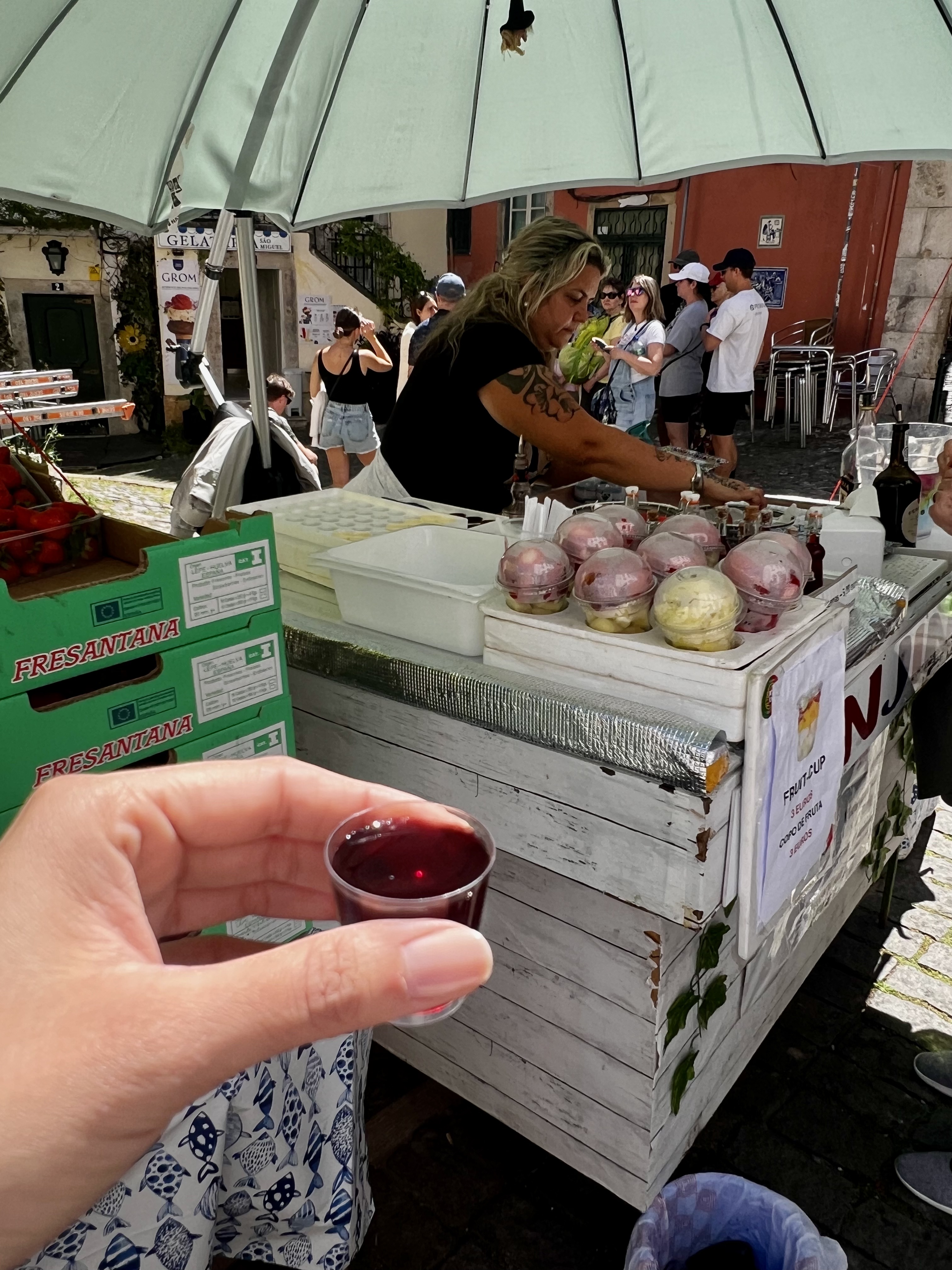 a hand holding a liquor drink in a shot glass 