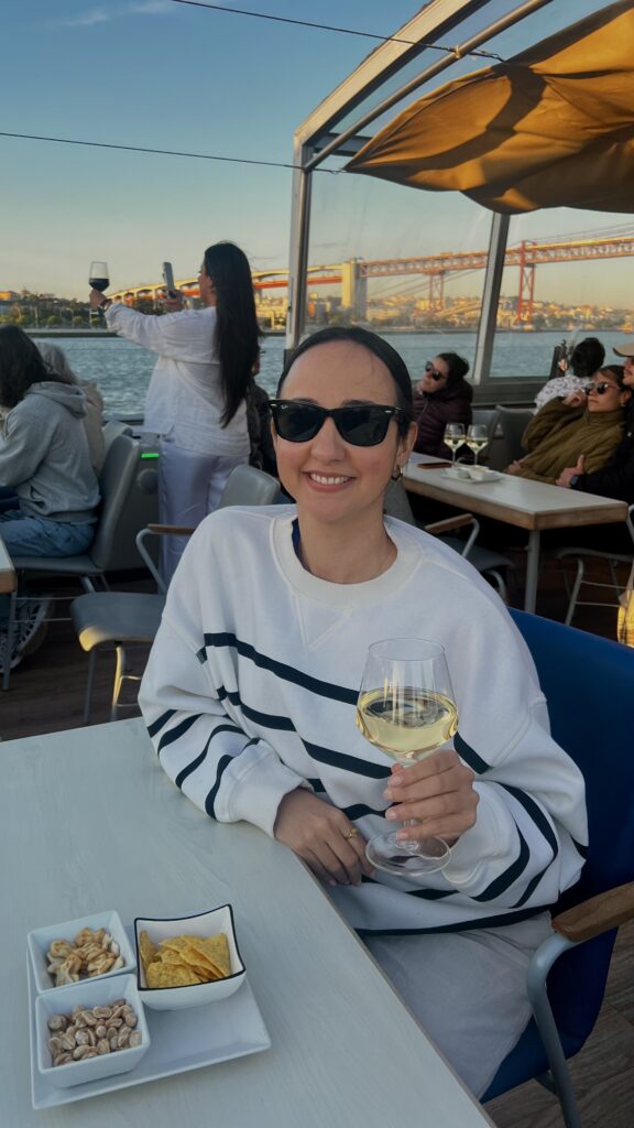 a woman smiling on a boat holding a glass of wine in her hand