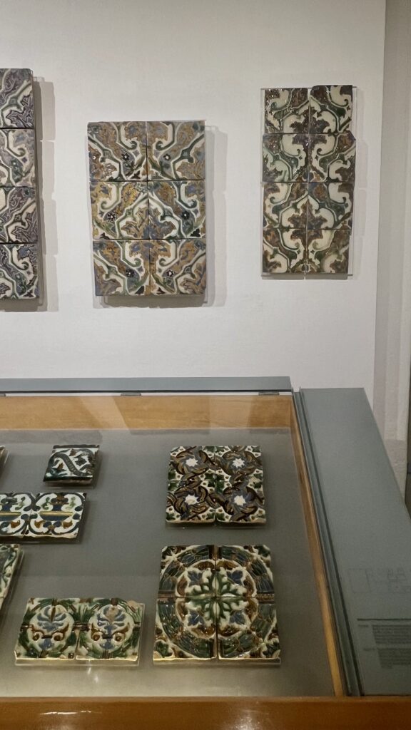 historic tiles displayed in a glass case in The National Tile Museum in Lisbon, Portugal