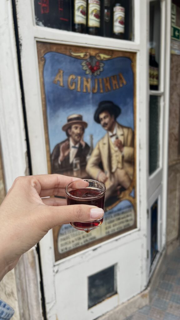 a hand holding a liquor drink in a shot glass 