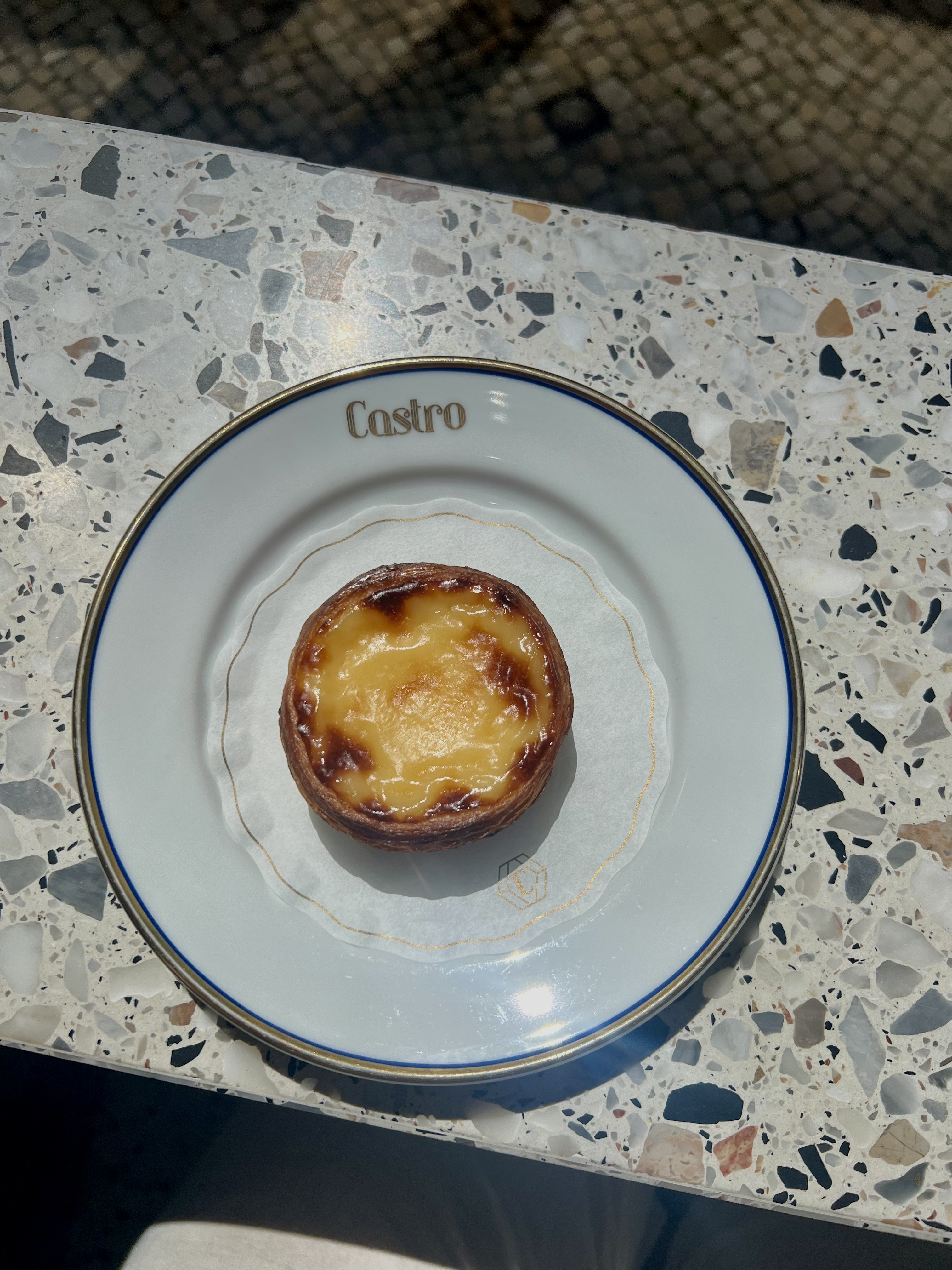 a flaky Portuguese pastry on a plate 