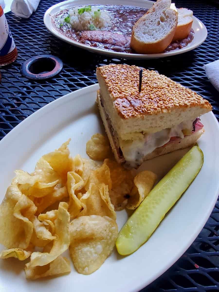 a plate with sandwich, chips, and a pickle 